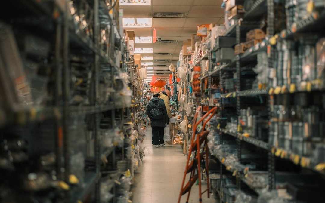 person-walks-down-aisle-of-stocked-warehouse-shelves-sf6yuxvcoro